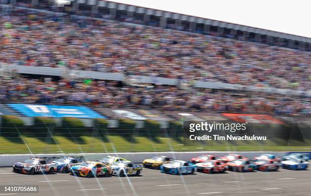 Denny Hamlin, driver of the FedEx Office Toyota, leads the field during the NASCAR Cup Series M&M's Fan Appreciation 400 at Pocono Raceway on July...