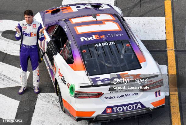 Denny Hamlin, driver of the FedEx Office Toyota, gestures after winning the NASCAR Cup Series M&M's Fan Appreciation 400 at Pocono Raceway on July...