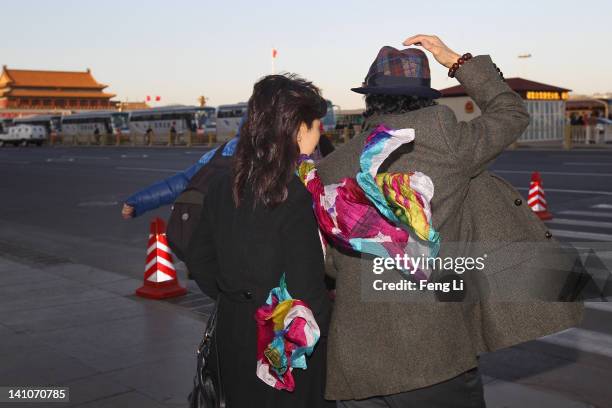 The delegates leaves The Great Hall Of The People in high winds after the third plenary meeting of the 11th National Committee of the Chinese...