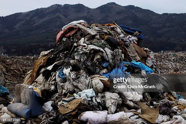 Large piles of household debris destroyed by the tsunami are seen at a sorting site on March 10, 2012 in Rikuzentakata, Japan. On the eve of the one...