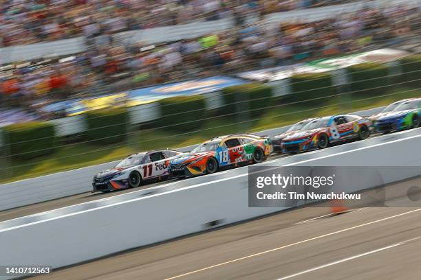 Denny Hamlin, driver of the FedEx Office Toyota, and Kyle Busch, driver of the M&Ms Toyota, lead the field during the NASCAR Cup Series M&M's Fan...