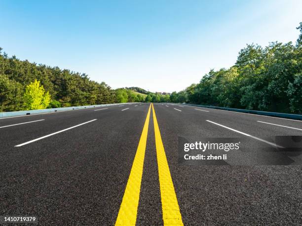 mountain highway through the trees - single yellow line stock pictures, royalty-free photos & images