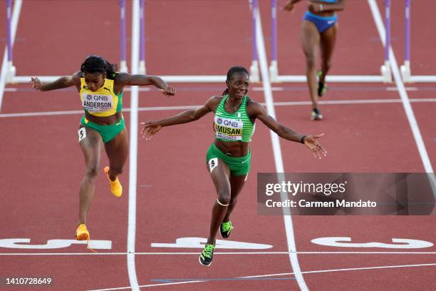 Britany Anderson of Team Jamaica and Tobi Amusan of Team Nigeria cross the finish line in the Women's 100m Hurdles Final on day ten of the World...