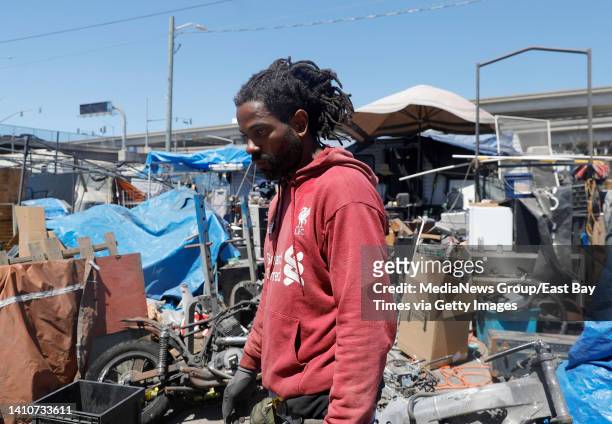 Alan Walker clears out an area at the Wood Street homeless encampment in Oakland, Calif., on Thursday, July 14, 2022. City officials sent in crews in...