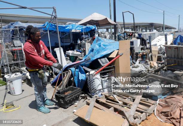 Alan Walker clears out an area at the Wood Street homeless encampment in Oakland, Calif., on Thursday, July 14, 2022. City officials sent in crews in...