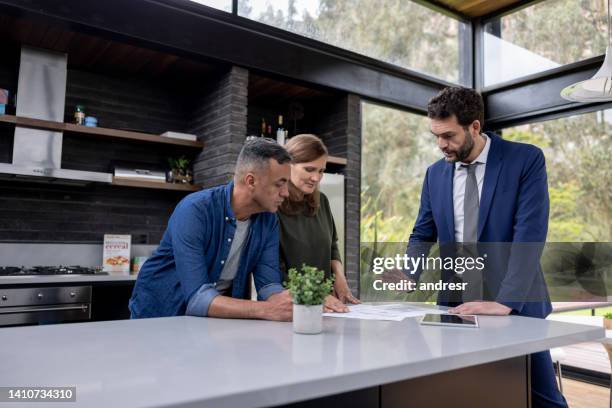 consulente finanziario che parla con una coppia dei loro investimenti immobiliari - venditore foto e immagini stock