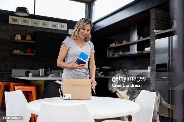 happy woman at home receiving a parcel in the mail - great dane home stock pictures, royalty-free photos & images