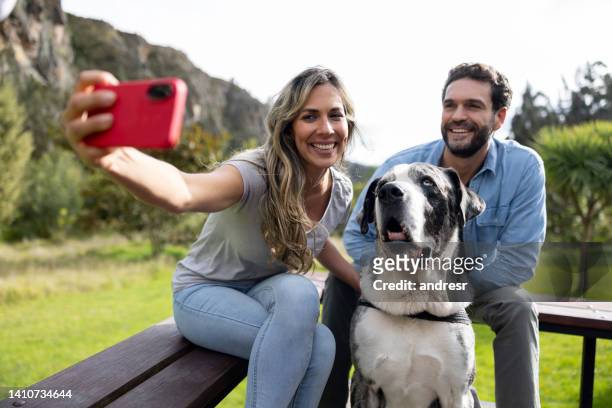 glückliches paar, das ein selfie mit seinem hund macht - mann frau hund zuhause stock-fotos und bilder