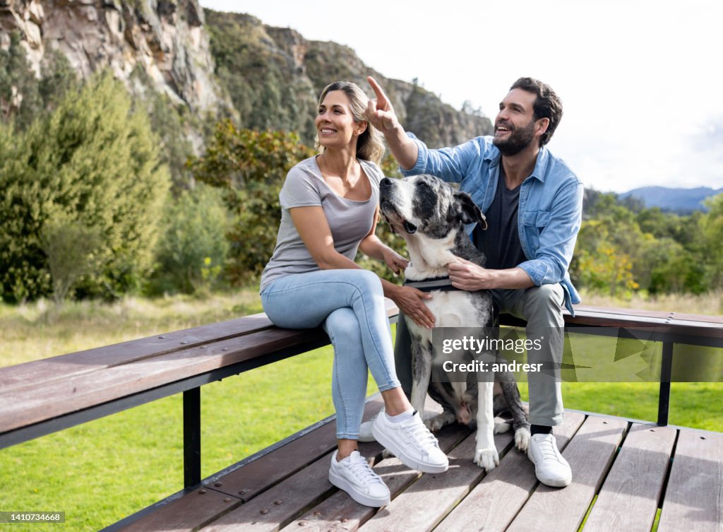 Happy couple relaxing with their dog in the terrace of their house