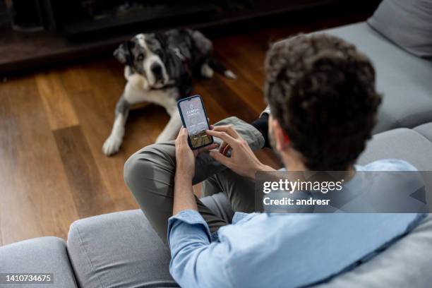 man at home with his dog and ordering food with a delivery app - great dane home stock pictures, royalty-free photos & images