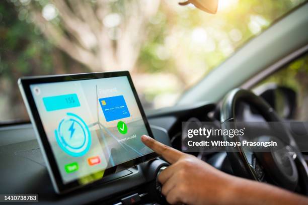 drivers use an app to pay for electric vehicle charging. the new look makes it possible to pay for gas and electric vehicle charging without having to get out of the car anymore. - hybrid car stock pictures, royalty-free photos & images