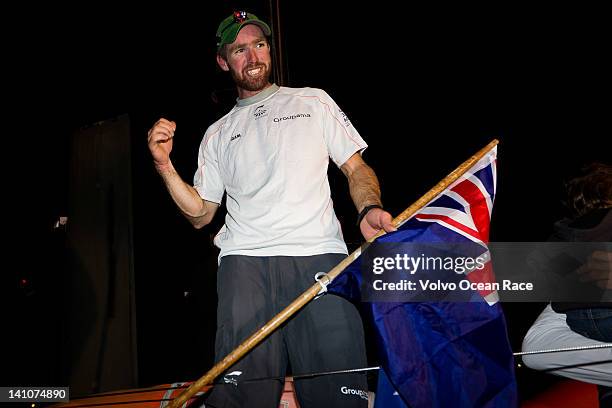 Brad Marsh from New Zealand holds his home flag onboard Groupama Sailing Team, finishing first in to Auckland harbour at night, on leg 4 from Sanya,...