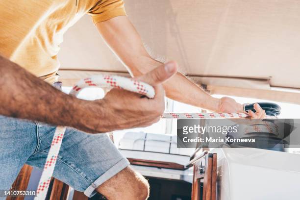 sailor operating the rope winch. - kabelwinden stock-fotos und bilder