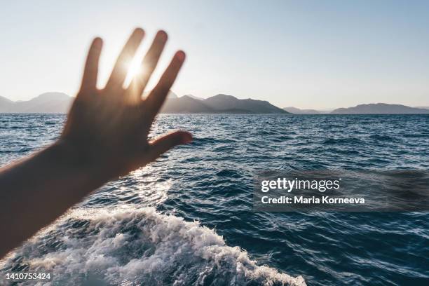 woman traveling on yacht at sunset in the sea. close up hand. - adriatic sea stock pictures, royalty-free photos & images