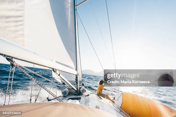 caucasian man sitting on yacht deck. - sail boat deck stock pictures, royalty-free photos & images