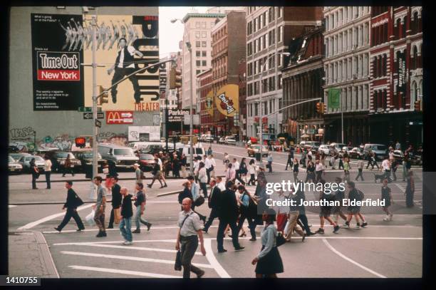 Pedestrians pass through the intersection of East Eighth Street, Lafayette Street and Astor Place in the East Village June 1, 1998 in New York City....