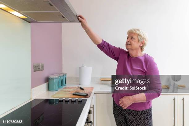 senior lady turning off lights - activation stockfoto's en -beelden