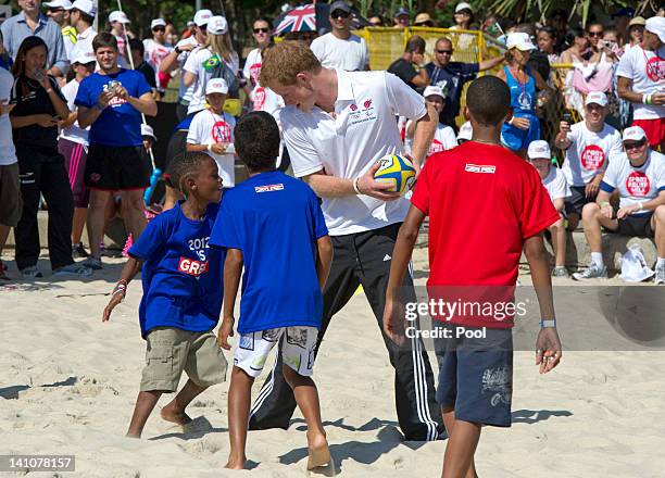 Prince Harry plays rugby with children during a Premiership Rugby training session on Flamengo Beach on March 10, 2012 in Rio De Janeiro, Brazil....