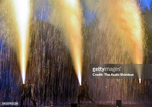 Pyrotechnicians hold bamboo cylinders containing fireworks as they perform 'Tezutsu Hanabi' or hand held fireworks during the Toyohashi Gion Festival...