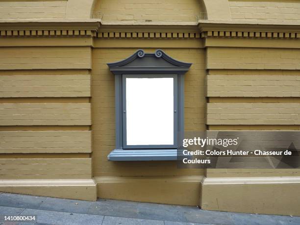 an empty billboard on a painted brick wall and sloping pavement in london, england, uk - theatre building stockfoto's en -beelden