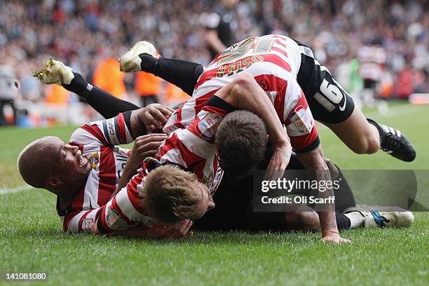 James Coppinger of Doncaster Rovers celebrates his goal with team-mates El-Hadji Diouf and John Oster during the npower Championship match between...