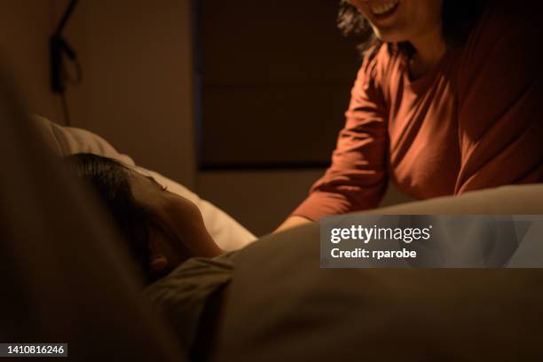 mother putting daughter to sleep - sleep routine stock pictures, royalty-free photos & images