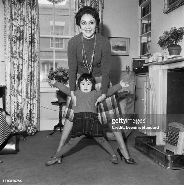 American actress and singer Chita Rivera, wearing a turtleneck sweater and playing with her daughter, Lisa Mordente, in London, England, 6th February...