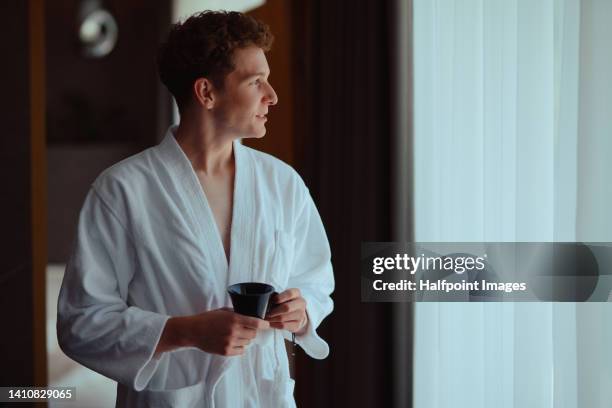 young man in bathrobe enjoying his morning coffee. - bathrobe stock pictures, royalty-free photos & images