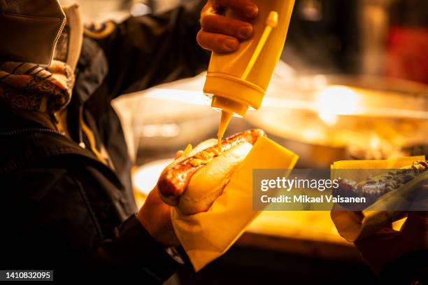 person putting mustard sauce on curry sausage - currywurst stock pictures, royalty-free photos & images