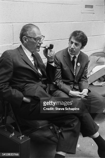 American playwright Arthur Miller smokes a pipe as he talks with actor Dustin Hoffman, New York, 1968. Hoffman waears a campaign button promoting...