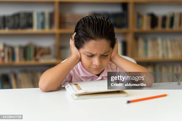 kleiner junge in der klasse mit kopf auf den händen und verwirrt - confused writing stock-fotos und bilder