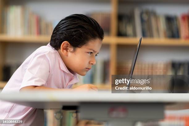little boy using computer and squinting - boy squinting stock pictures, royalty-free photos & images