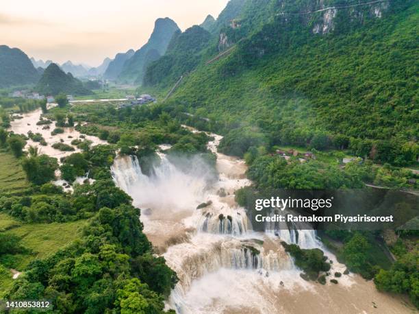 aerial drone sunset scene of ban gioc detian waterfall at the border of china and vietnam - grenzbaum stock-fotos und bilder