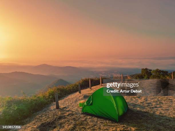 camping with a tent during sunrise with beautiful mountain view above the clouds. - campfire background stock pictures, royalty-free photos & images