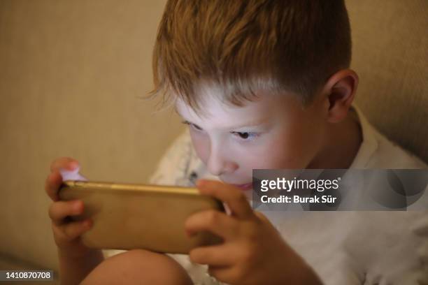 myopia symptoms, child plays video game with phone - myopia 個照片及圖片檔