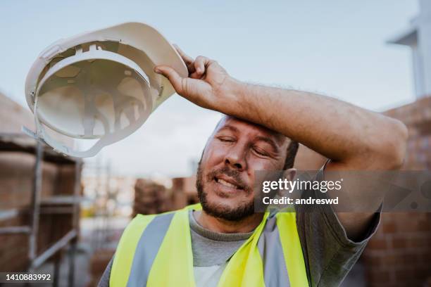 retrato de un hombre exhausto en el sitio de construcción - hard fotografías e imágenes de stock