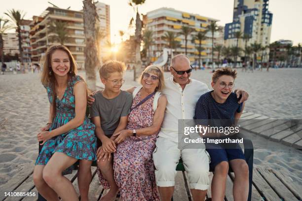 famiglia multi generazione che cammina sulla bellissima spiaggia - five people foto e immagini stock