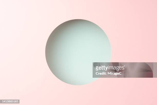 round frame composed of pink and turquoise colored paper - hole foto e immagini stock