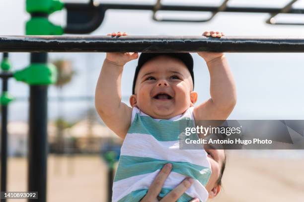 baby doing fitness on a beach. family and outdoor sports. - male gymnast photos et images de collection