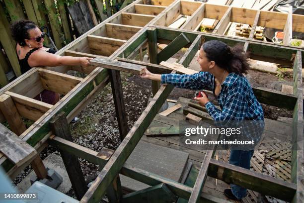 mature mother and teenage daughter constructing a terrace in backyard. - man made stock pictures, royalty-free photos & images