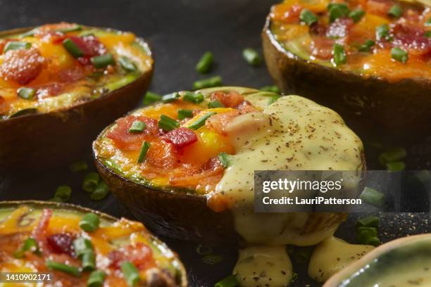 baked avocado egg boats with hollandaise sauce - stuffed avocado stock pictures, royalty-free photos & images