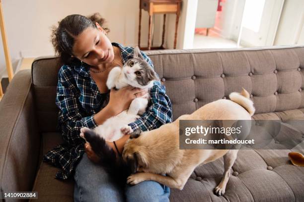 adolescente à moitié cubaine et ses animaux de compagnie à la maison. - chat et chien photos et images de collection