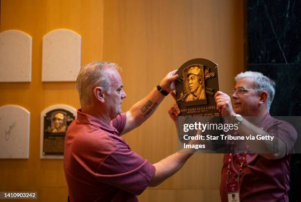 Curator John Odell handed Tony Olivas plaque to Liam Delaney, left, for installation in the hall with the other inductees Sunday evening, July 24,...