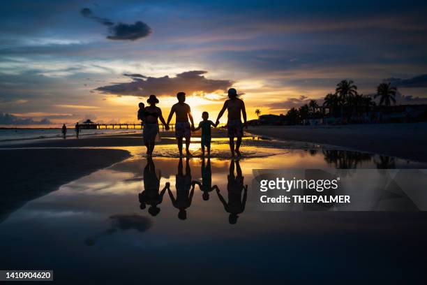 latin family walking on the beach at sunset in ft myers florida - fort myers beach stock pictures, royalty-free photos & images