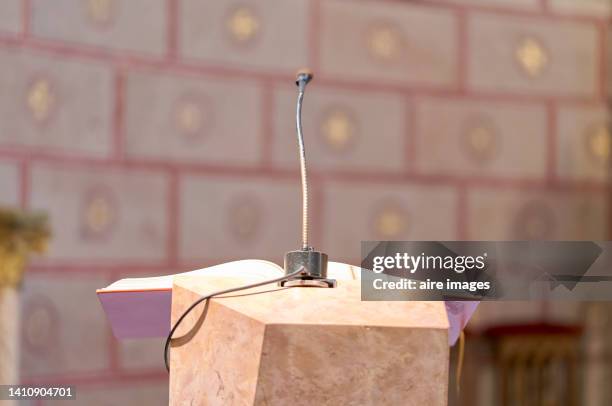 microphone only on the podium where the holy bible is located in a christian catholic church - victory parish stock pictures, royalty-free photos & images