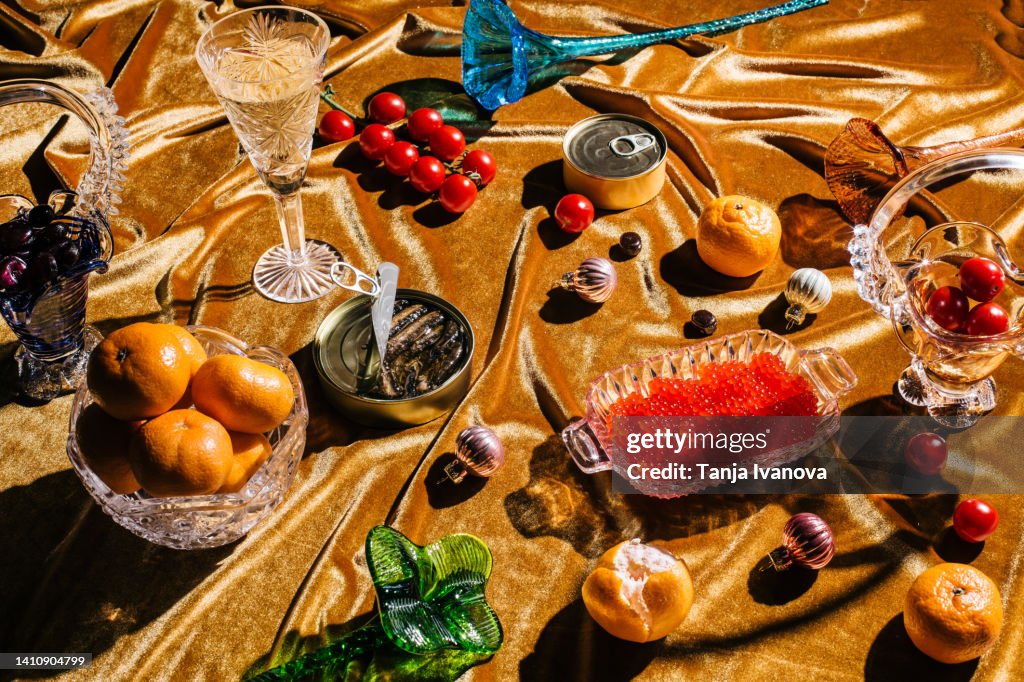Xmas modern dinner table setting on gold velvet fabric background. Creative Merry Christmas celebration concept. Contemporary New Year festive backdrop