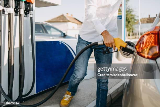 handsome man fills his car at the gas station. - biodiesel stock pictures, royalty-free photos & images