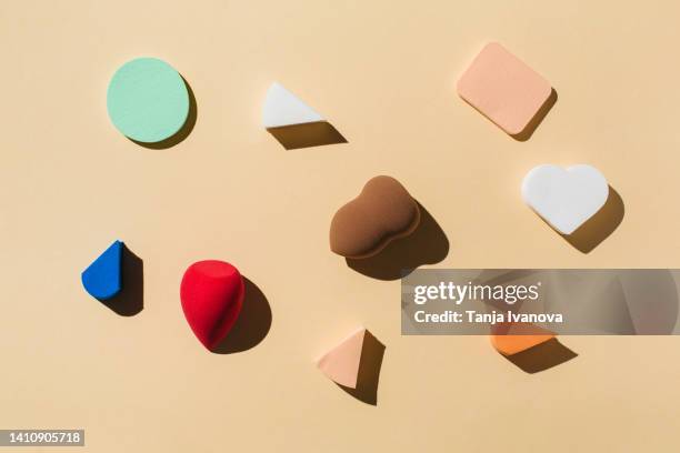 colorful sponges for make up on beige background. - gesichtspuder stock-fotos und bilder