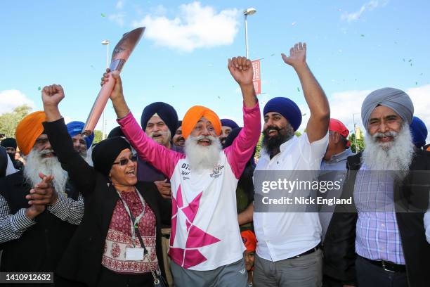 Batonbearer Parmjit Singh holds the Queen's Baton during the Birmingham 2022 Queen's Baton Relay on July 25 Smethwick, United Kingdom.