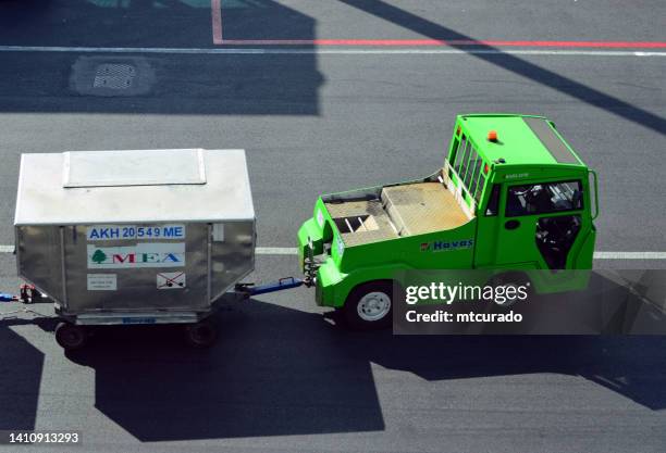 towing tractor and uld - luggage trolley stockfoto's en -beelden